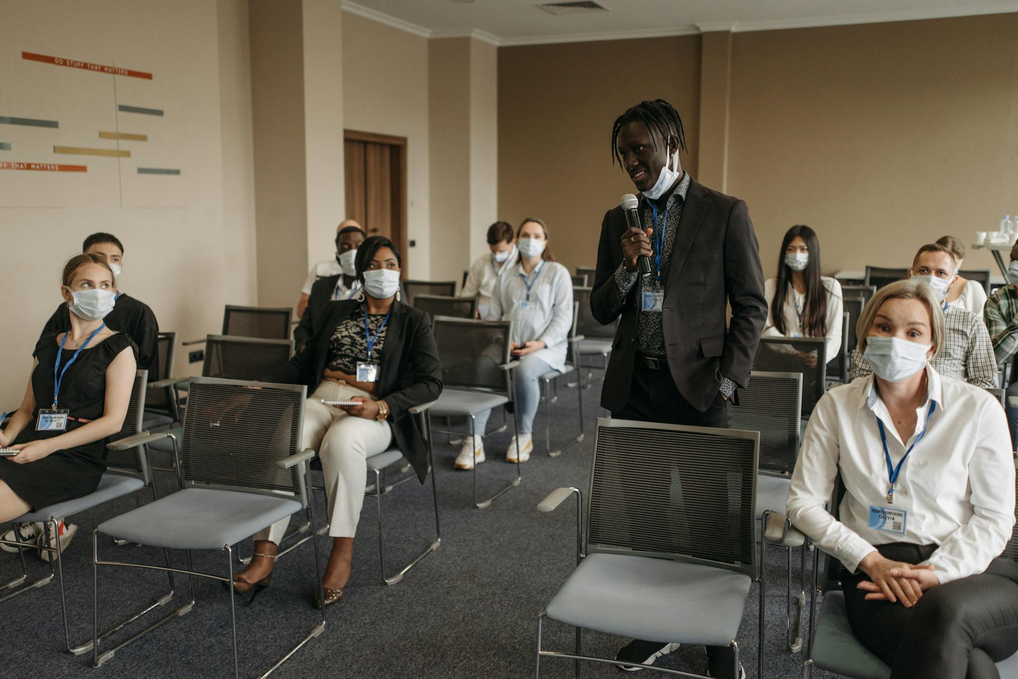 Business meeting with diverse participants wearing masks. Pandemic safety protocols in a conference room.